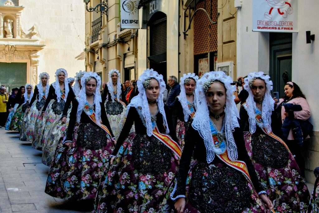 Women in traditional dresses during a parade in Alicante, Spain.