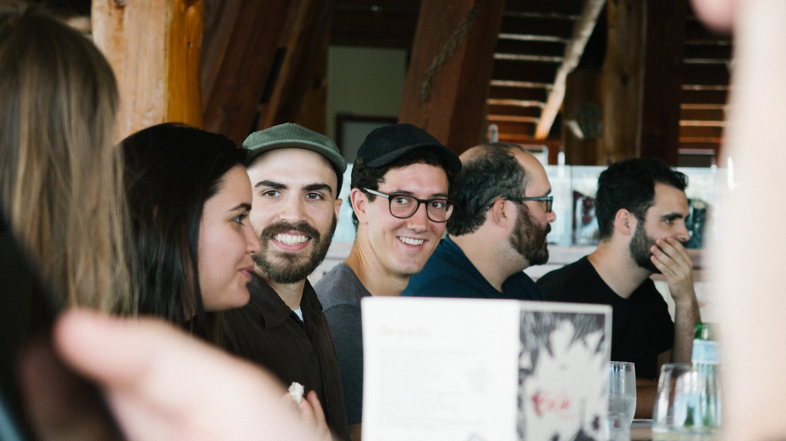 A lively group of friends engaging in conversation at a cozy indoor setting.