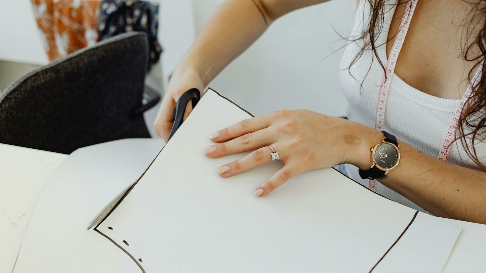 Woman cutting sewing pattern with scissors, embodying creativity and craftsmanship.